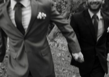 Gay couple running trought the park, feeling happy